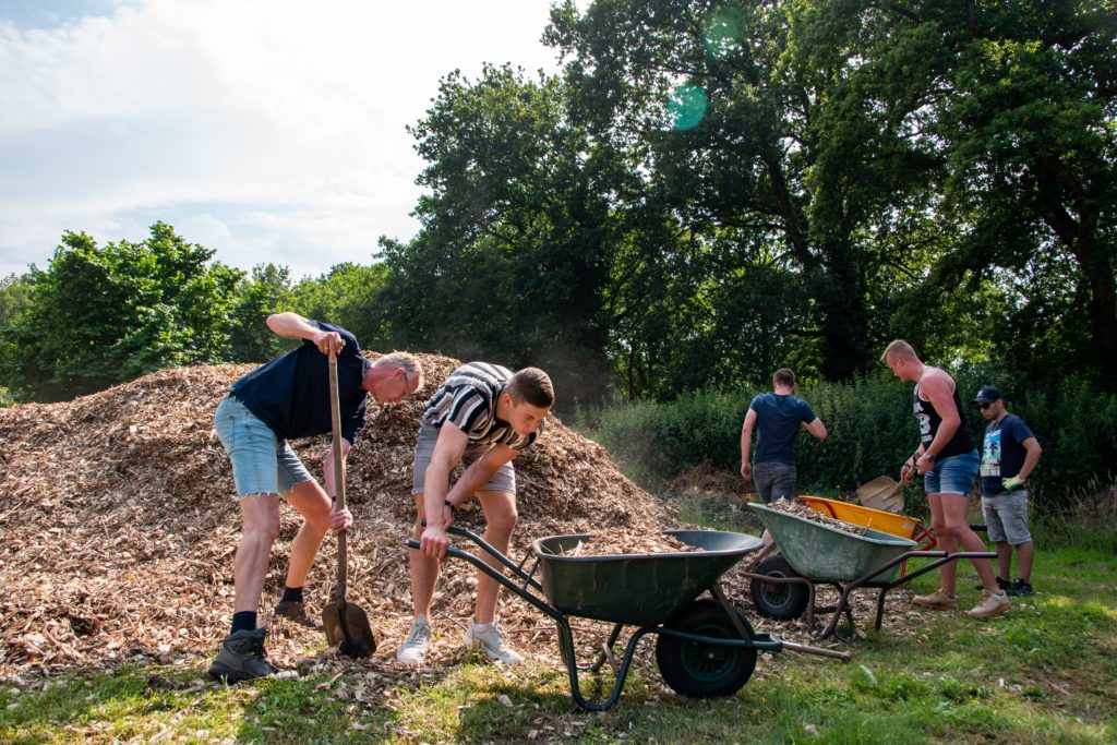 Hier worden de houtsnippers in de kruiwagens geschept